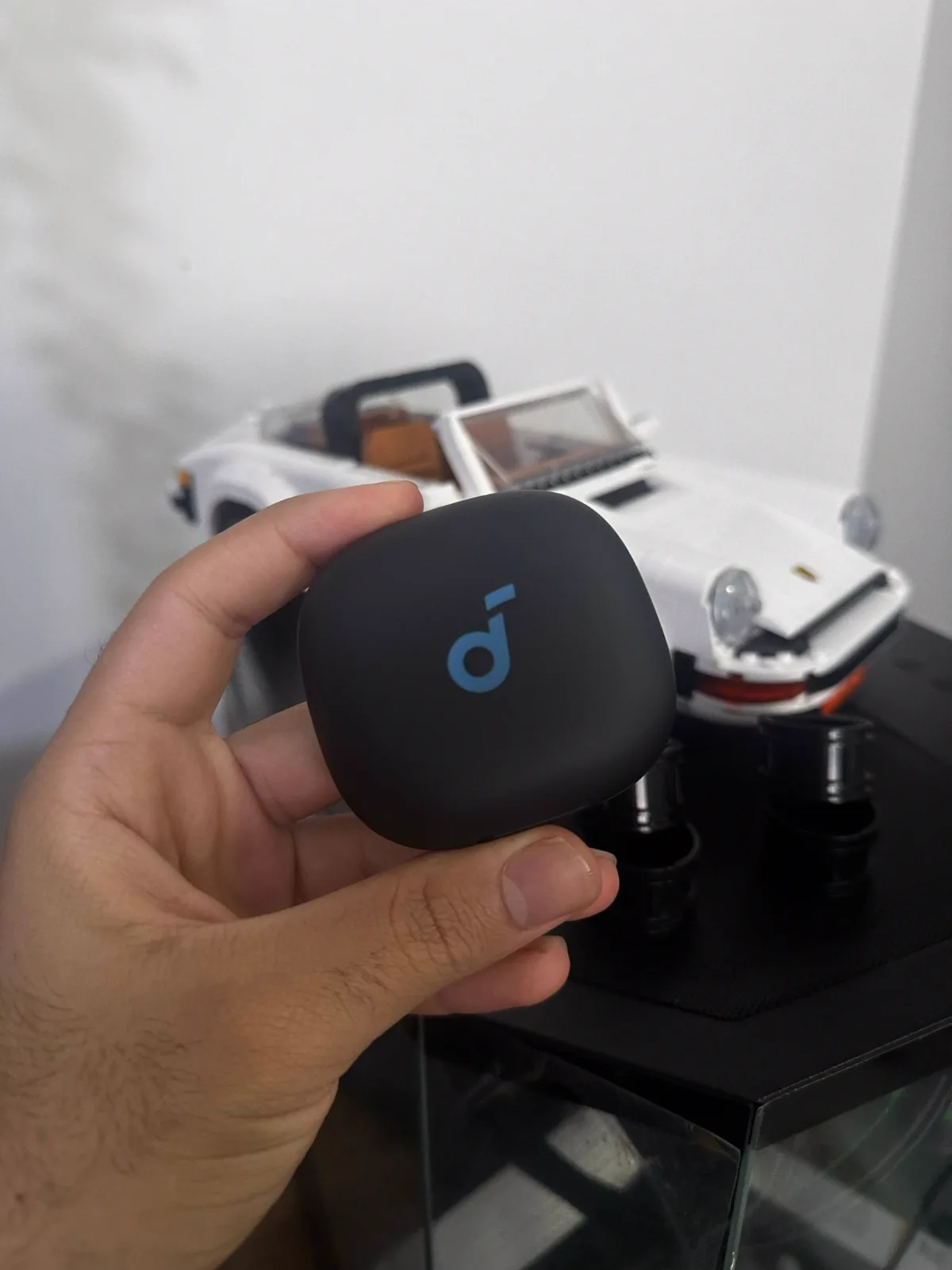 The closed charging case of the soundcore Sport X20 held in one hand.