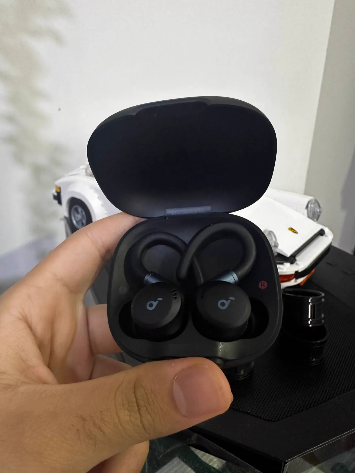 My soundcore Sport X20 earbuds in their open case, showing the ear hooks.